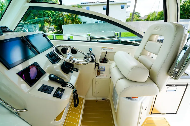 Slide: The Image of Helm of 2018 Boston Whaler 315 Conquest with modern navigation equipment and comfortable seating. - 15