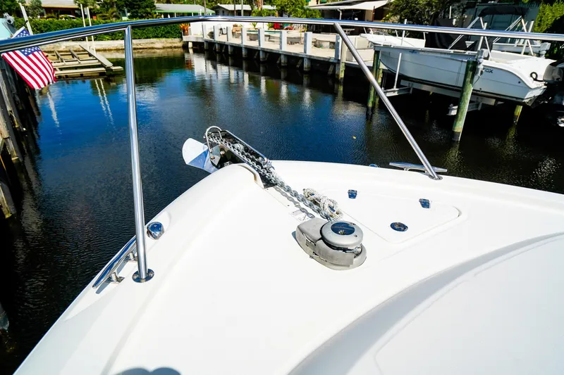 Slide: The Image of 2018 Boston Whaler 315 Conquest boat bow with anchor chain, docked near calm water. - 28