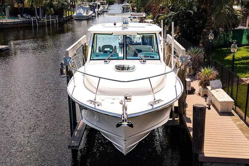 Slide: The Image of 2018 Boston Whaler 315 Conquest docked in a scenic canal setting. - 33
