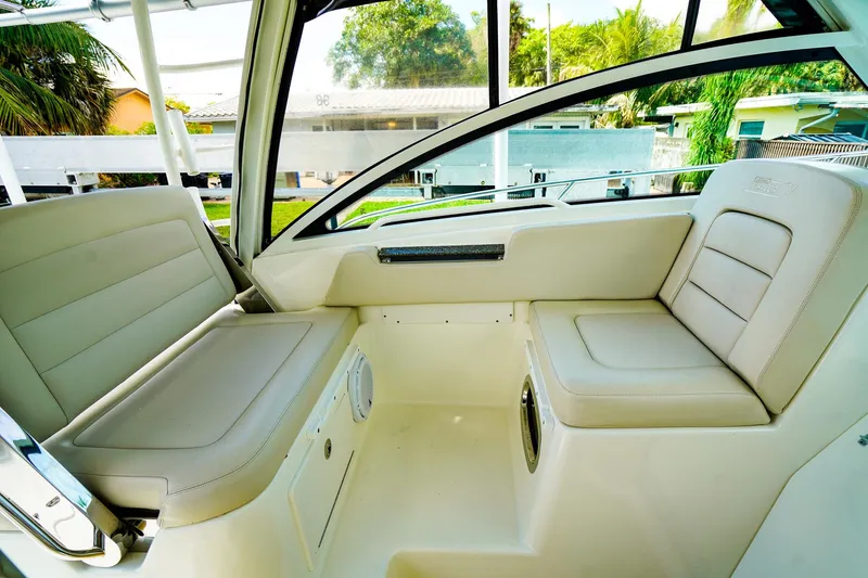 Slide: The Image of Interior seating of 2018 Boston Whaler 315 Conquest boat, featuring beige cushioned seats. - 14