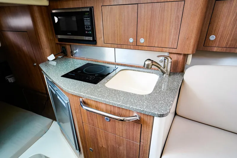 Slide: The Image of 2018 Boston Whaler 315 Conquest galley with sink, stove, and microwave. - 24