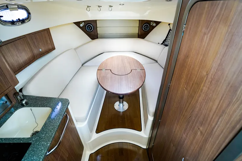 Slide: The Image of 2018 Boston Whaler 315 Conquest cabin interior with seating and table. - 18