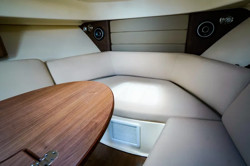 Slide: The Image of Interior of 2018 Boston Whaler 315 Conquest, featuring a cozy seating area and wooden table. - 20