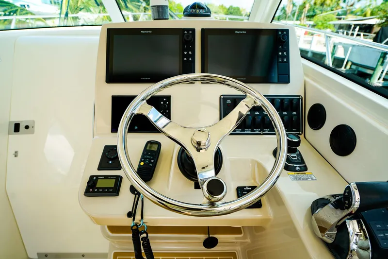 Slide: The Image of Helm of 2018 Boston Whaler 315 Conquest with dual Raymarine displays and chrome steering wheel. - 17