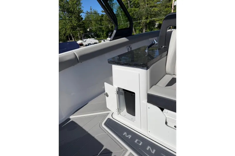 Slide: The Image of 2027 Monterey Elite 30 OB boat interior with sleek seating and storage compartment. - 13