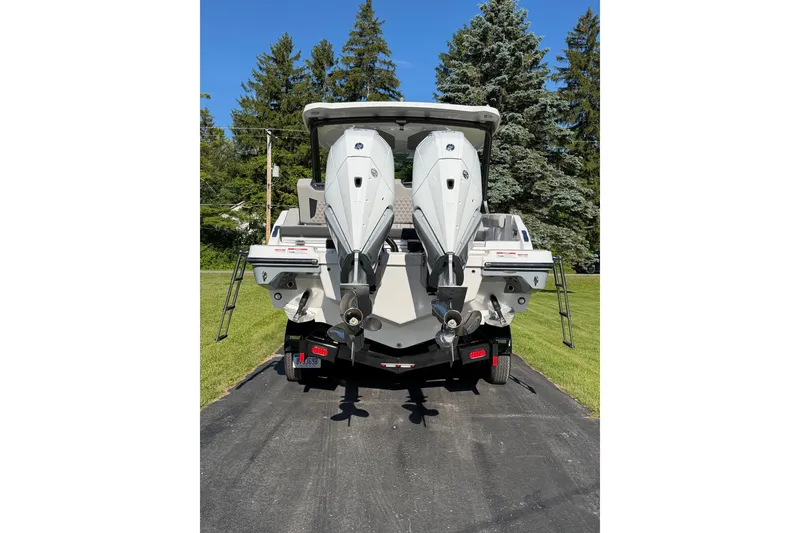 Slide: The Image of 2027 Monterey Elite 30 OB boat with dual outboard engines on a driveway. - 5