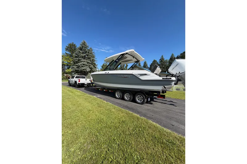 Slide: The Image of 2027 Monterey Elite 30 OB boat on trailer, parked on driveway under clear blue sky. - 26
