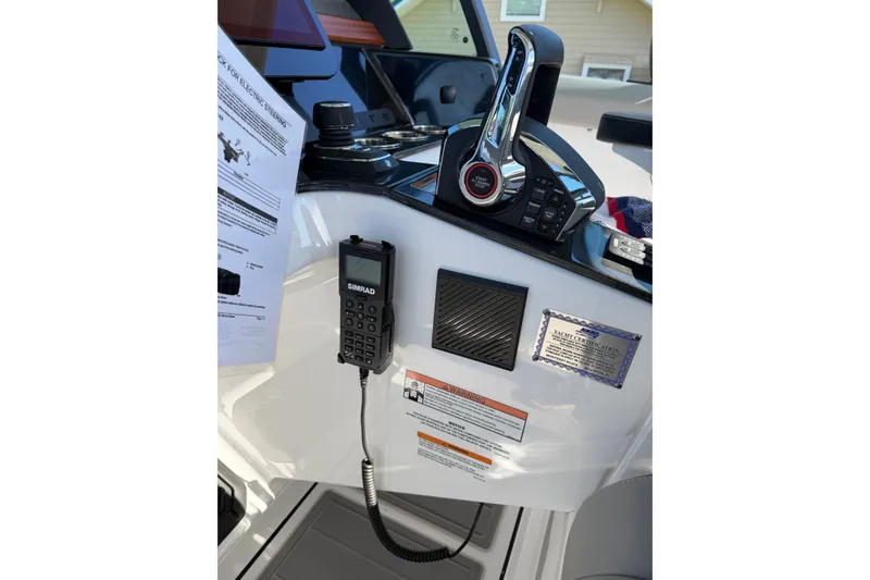 Slide: The Image of Control panel of 2027 Monterey Elite 30 OB boat with Simrad radio and throttle controls. - 14