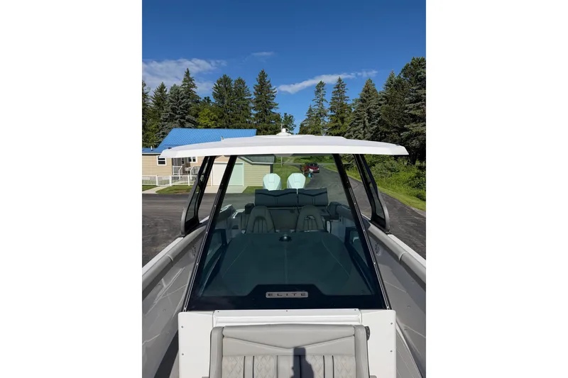 Slide: The Image of 2027 Monterey Elite 30 OB boat with sleek design, parked outdoors under clear blue sky. - 24