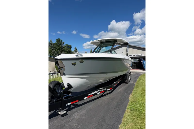 Slide: The Image of 2027 Monterey Elite 30 OB boat on trailer under blue sky near showroom. - 4