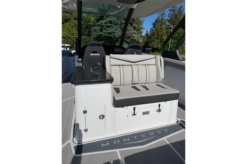 Slide: The Image of 2027 Monterey Elite 30 OB boat interior with cushioned seating and Yeti cooler. - 11