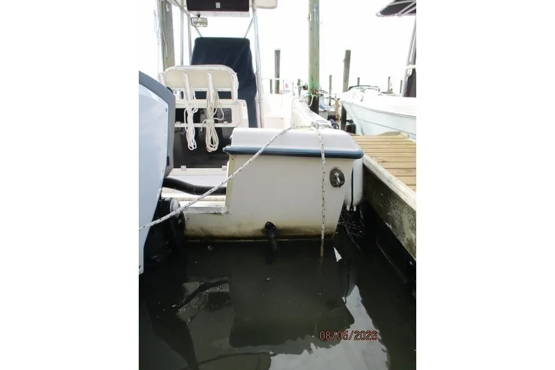 Slide: The Image of Grady-White Escape 209 boat docked, partially submerged, with visible engine and seating. - 57