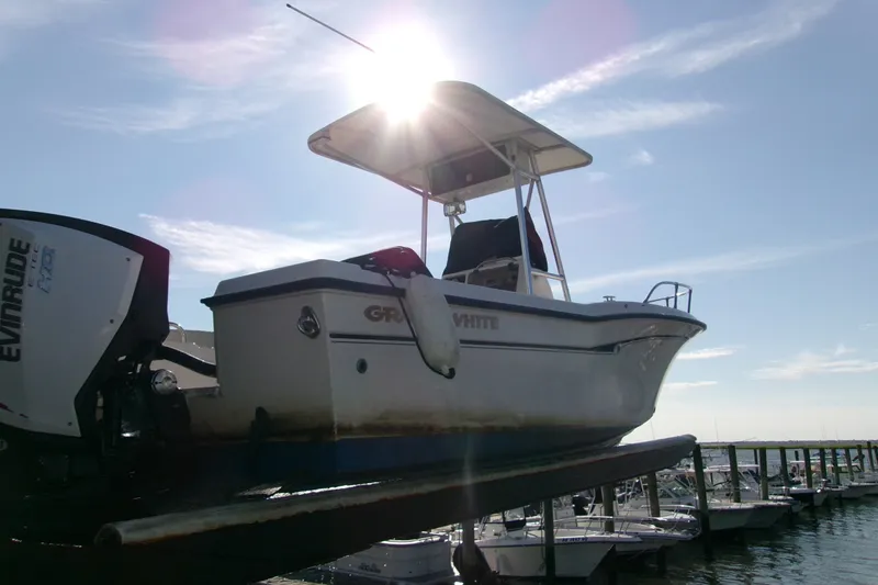 Slide: The Image of 2000 Grady-White Escape 209 boat with Evinrude engine, docked under bright sun. - 23
