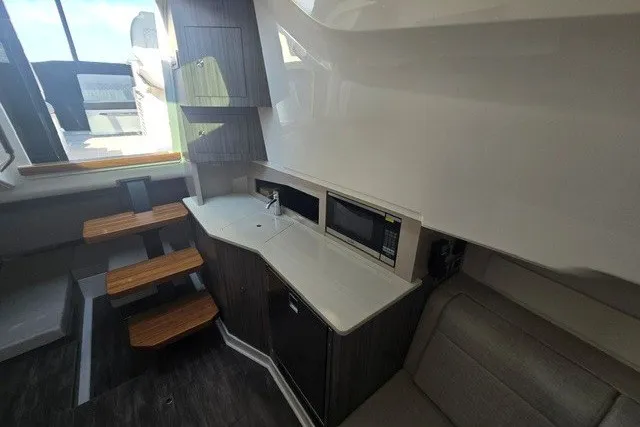 Slide: The Image of Interior of 2024 Sea Ray Sundancer 370 Outboard, featuring modern kitchenette and seating area. - 15