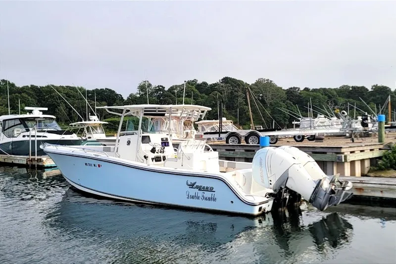 Slide: The Image of 2018 Mako 284 Center Console boat docked at marina with twin engines. - 31