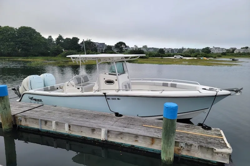 Slide: The Image of 2018 Mako 284 Center Console boat docked on a calm lake. - 32