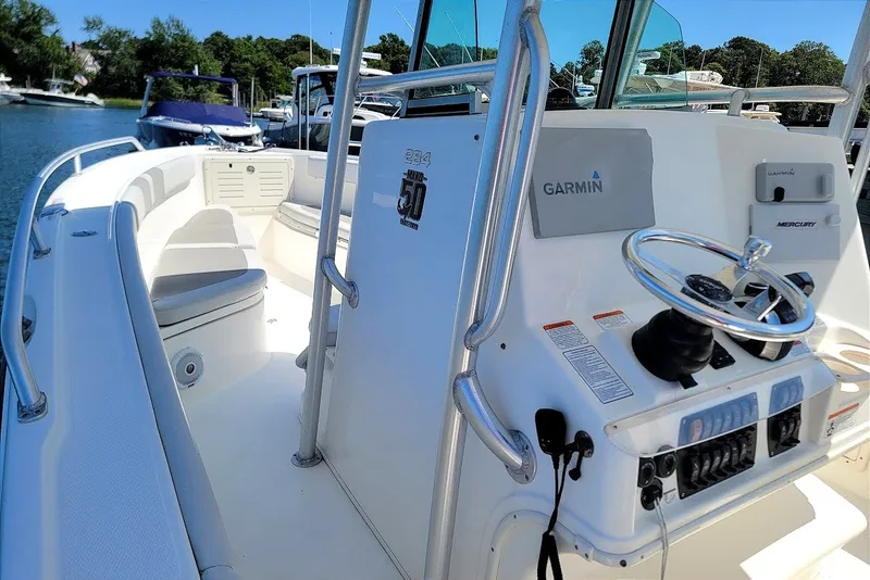 Slide: The Image of 2018 Mako 284 Center Console boat with Garmin navigation system, docked in a marina. - 22