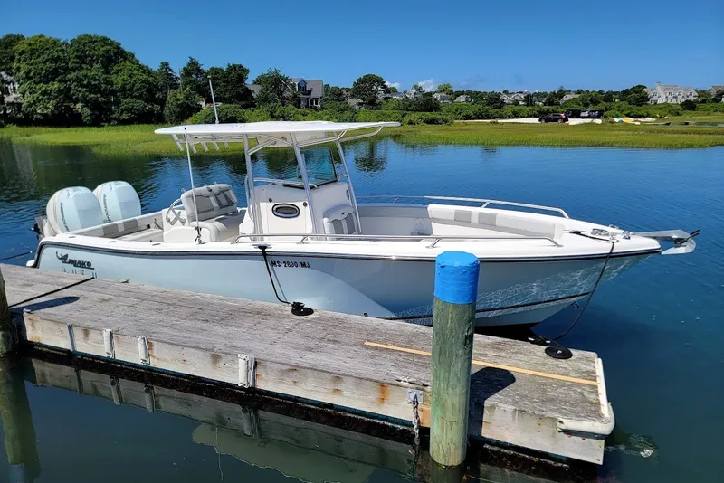 Slide: The Image of 2018 Mako 284 Center Console boat docked on a sunny day. - 14