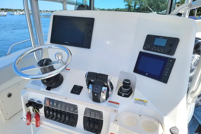 Slide: The Image of 2018 Mako 284 Center Console boat dashboard with steering wheel and navigation controls. - 20