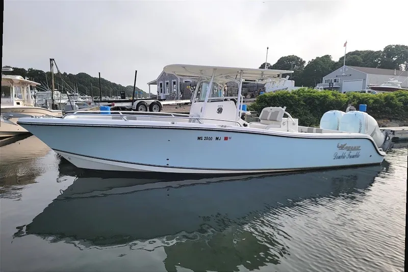 Slide: The Image of 2018 Mako 284 Center Console boat docked at a marina, side view. - 30