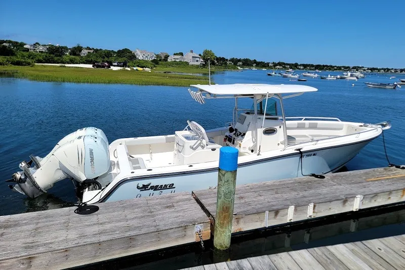 Slide: The Image of 2018 Mako 284 Center Console boat docked on a sunny day. - 16