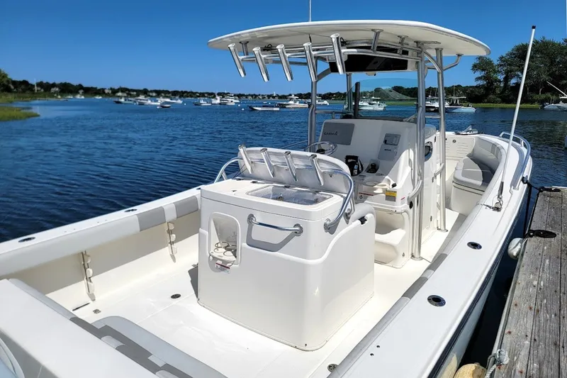 Slide: The Image of 2018 Mako 284 Center Console boat docked on a sunny day by the water. - 26