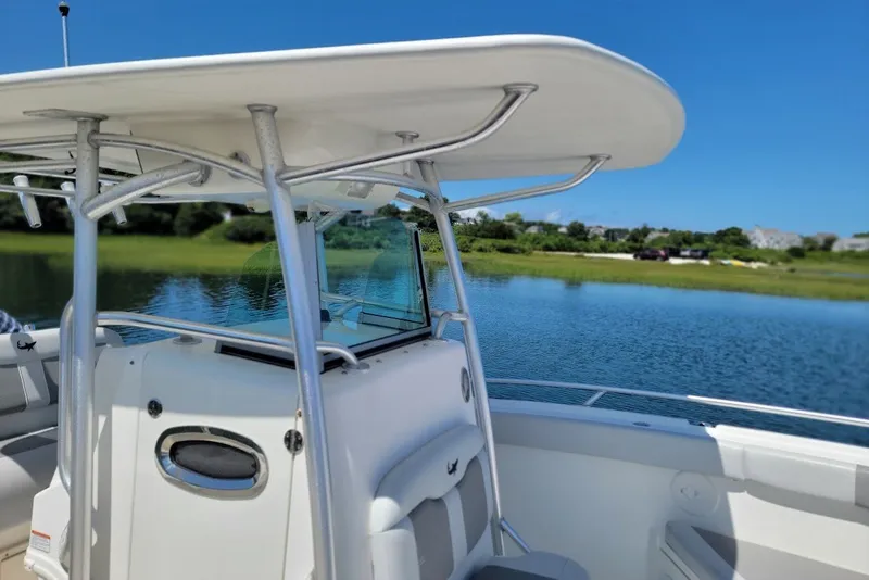 Slide: The Image of 2018 Mako 284 Center Console boat on a serene lake with clear blue skies. - 13