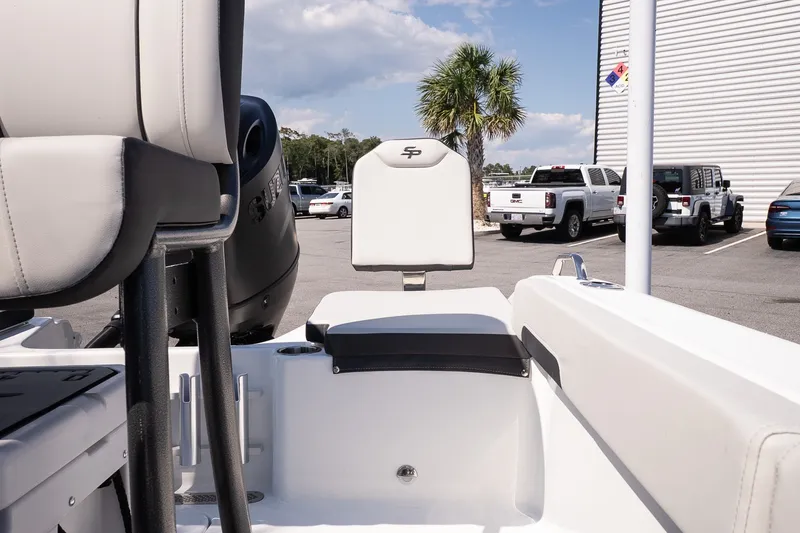 Slide: The Image of 2027 Sea Pro 202 Center Console boat interior with seating, parked vehicles, and palm tree in background. - 17