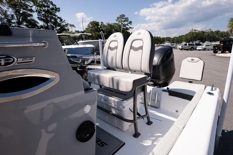Slide: The Image of 2027 Sea Pro 202 Center Console boat with dual seats and modern design in a sunny marina. - 14