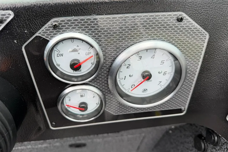 Slide: The Image of Dashboard gauges of 2027 Lund 1775 Impact XS Sport boat, featuring trim and fuel indicators. - 25