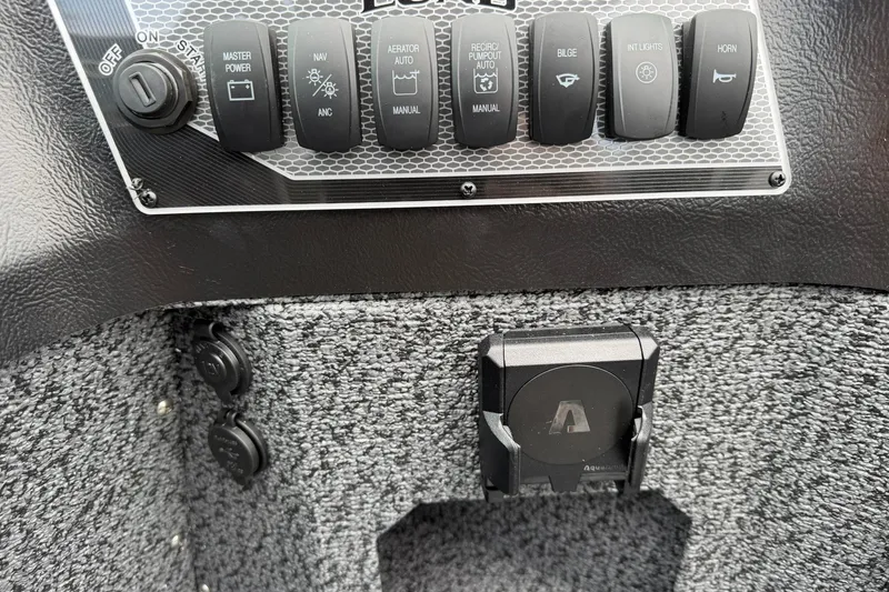 Slide: The Image of Control panel of 2027 Lund 1775 Impact XS Sport boat with various switches and outlets. - 18