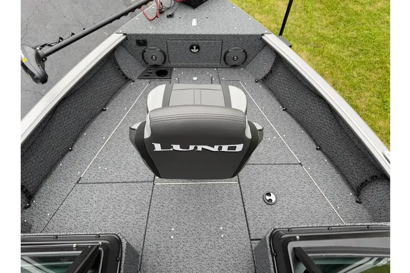 Slide: The Image of 2027 Lund 1775 Impact XS Sport boat interior with gray seating and carpeted deck. - 7