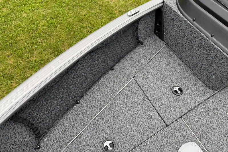 Slide: The Image of 2027 Lund 1775 Impact XS Sport boat interior with gray textured flooring and storage compartments. - 22
