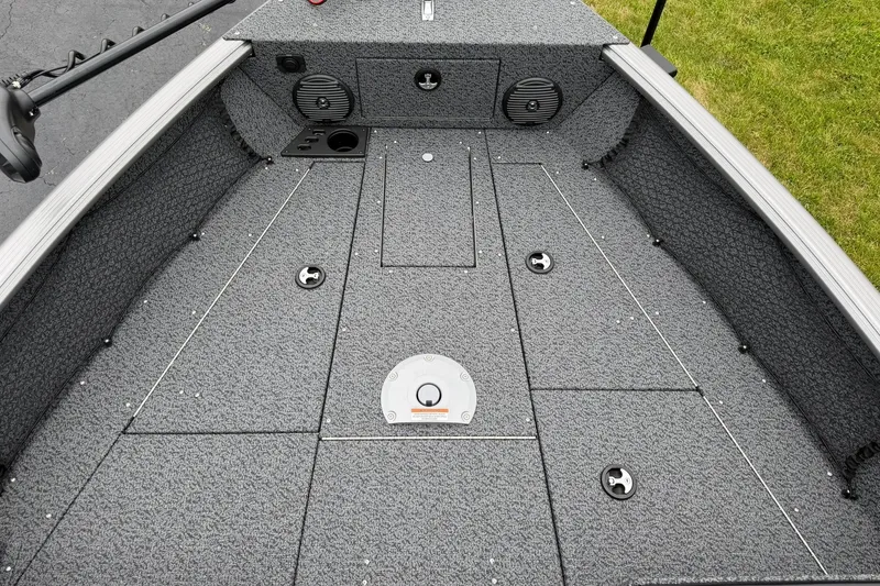 Slide: The Image of 2027 Lund 1775 Impact XS Sport boat interior with carpeted deck and storage compartments. - 20