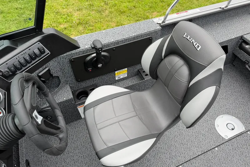 Slide: The Image of 2027 Lund 1775 Impact XS Sport boat interior with steering wheel and cushioned seat. - 19