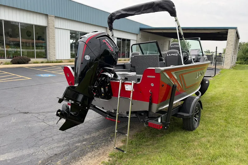 Slide: The Image of 2027 Lund 1775 Impact XS Sport boat with powerful outboard motor, parked outdoors. - 3