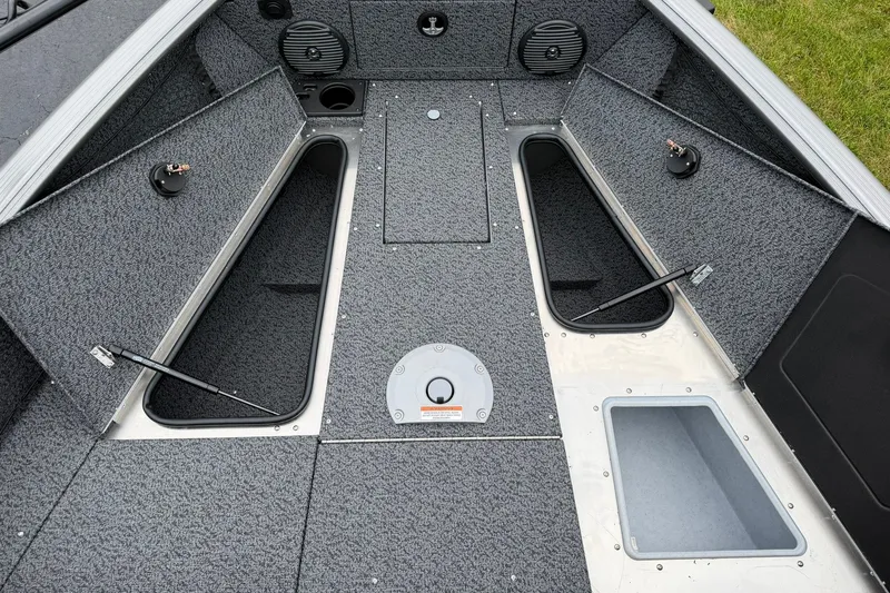 Slide: The Image of 2027 Lund 1775 Impact XS Sport boat interior with open storage compartments and speakers. - 21