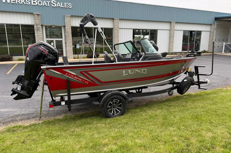 Slide: The Image of 2027 Lund 1775 Impact XS Sport boat on trailer outside dealership. - 2