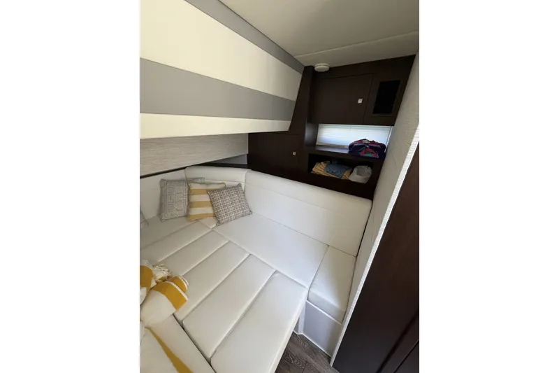 Slide: The Image of 2024 Cruisers Yachts 42 GLS OB interior cabin with white seating and decorative pillows. - 24
