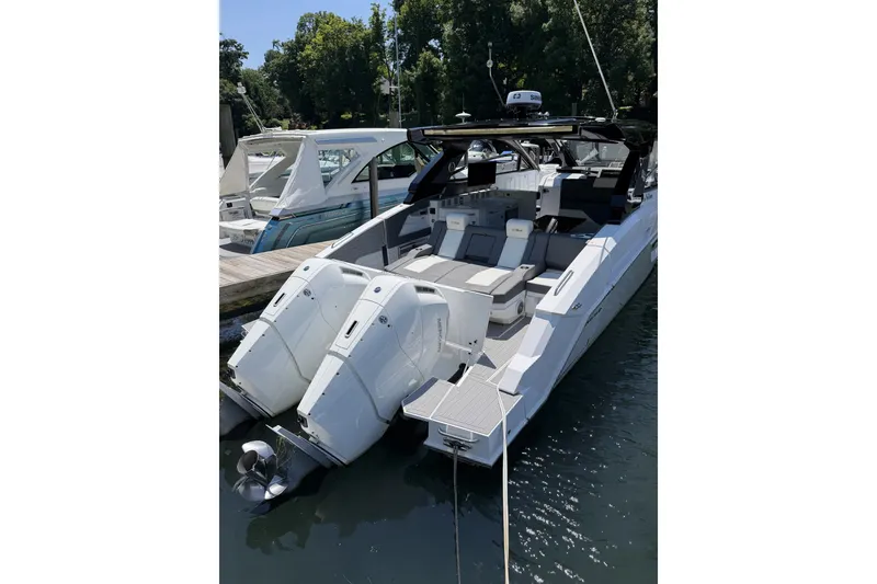Slide: The Image of 2024 Cruisers Yachts 42 GLS OB with dual outboard engines docked in a marina. - 2