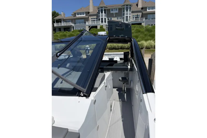 Slide: The Image of 2024 Cruisers Yachts 42 GLS OB, sleek design, docked near luxury waterfront homes. - 18