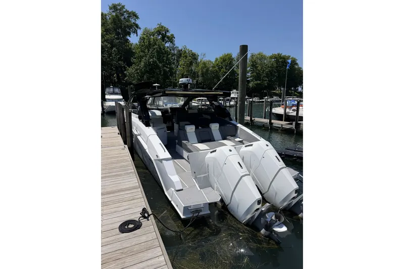 Slide: The Image of 2024 Cruisers Yachts 42 GLS OB docked, showcasing sleek design and powerful outboard engines. - 3