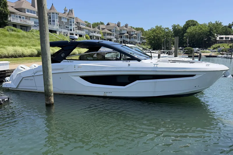 The Image of 2024 Cruisers Yachts 42 GLS OB docked in a scenic marina setting. - 0