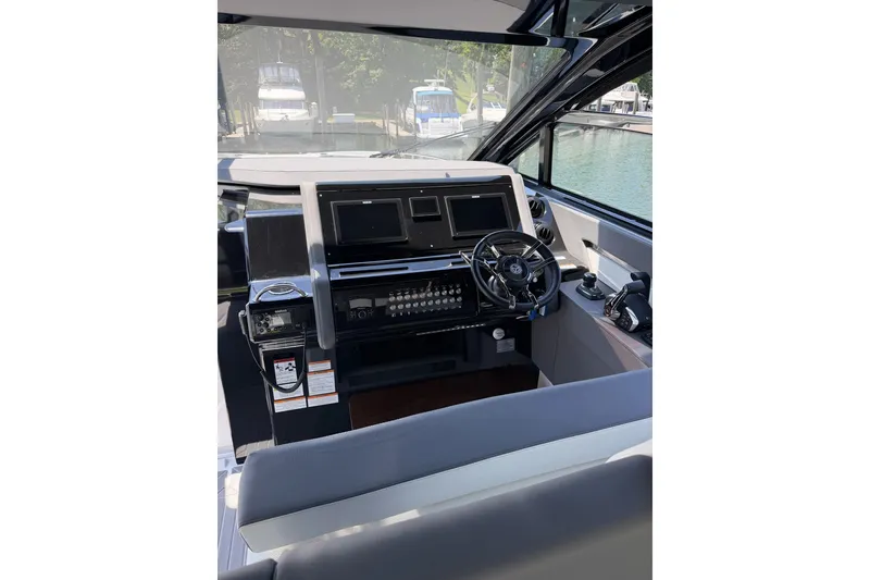 Slide: The Image of Helm of 2024 Cruisers Yachts 42 GLS OB with modern controls and navigation screens. - 12
