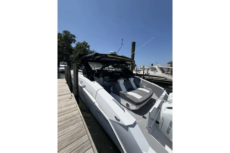 Slide: The Image of 2024 Cruisers Yachts 42 GLS OB docked, showcasing sleek design and luxurious seating. - 1