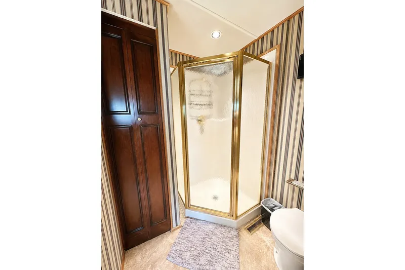 Slide: The Image of Luxurious bathroom in 1997 Sumerset 16x83 houseboat with gold-framed shower and wooden cabinet. - 11