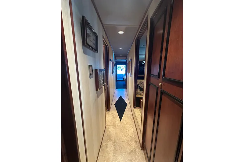 Slide: The Image of Hallway inside a 1997 Sumerset 16x83 houseboat, featuring wood paneling and framed artwork. - 9