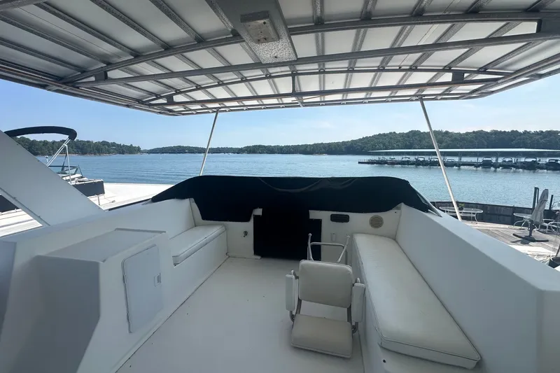 Slide: The Image of 1997 Sumerset 16x83 houseboat deck with seating, overlooking serene lake and marina. - 13