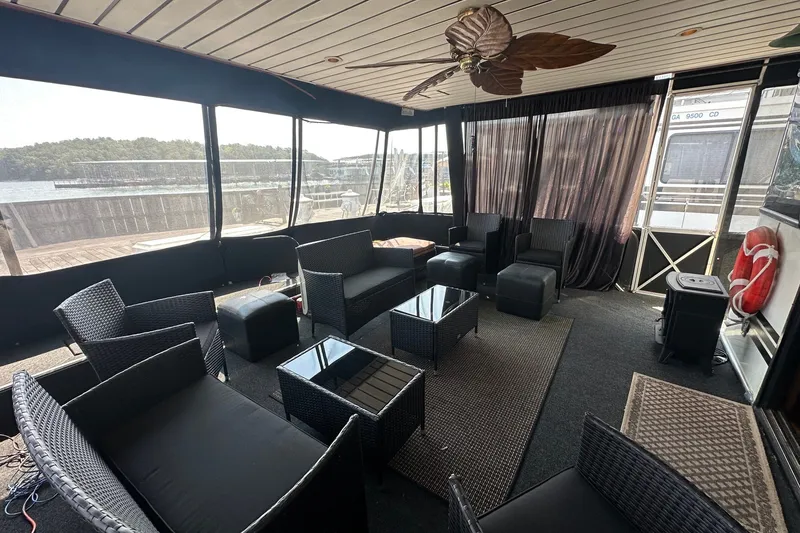 Slide: The Image of Luxurious 1997 Sumerset 16x83 houseboat interior with wicker furniture and lake view. - 1