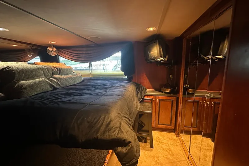 Slide: The Image of Cozy bedroom interior of 1997 Sumerset 16x83 houseboat with wood cabinets and TV. - 6